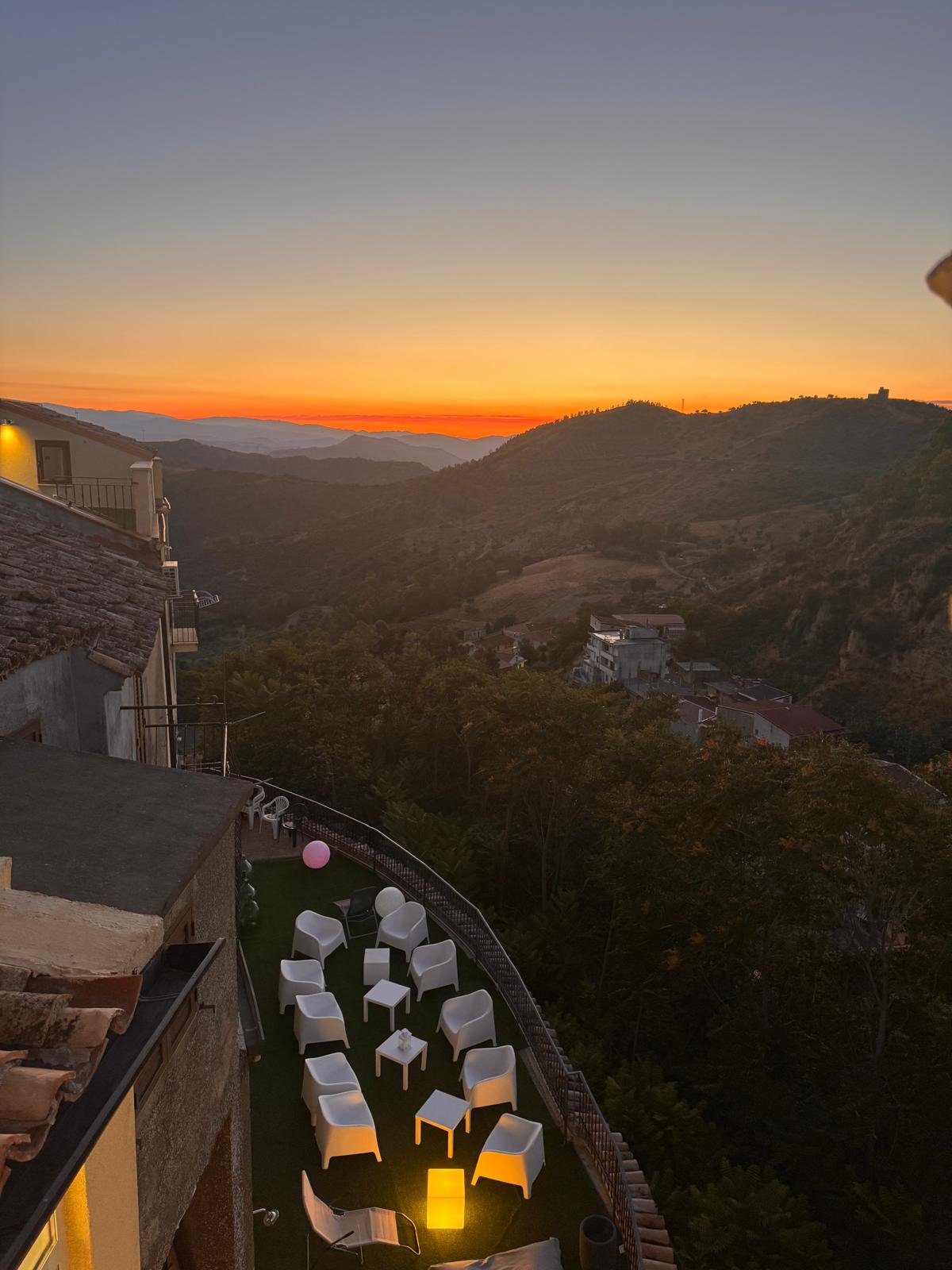 Tramonto dalle terrazze, con il salotto all'aperto e il panorama sulle colline