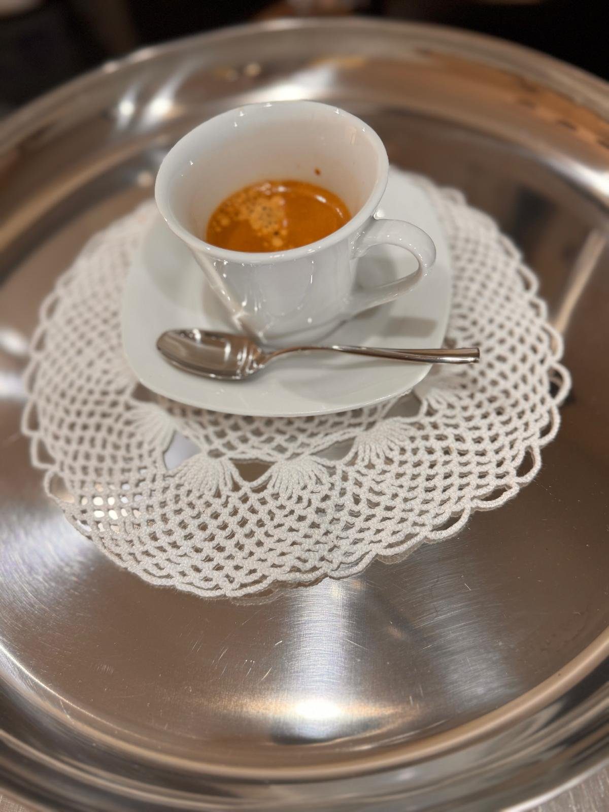Espresso servito sul vassoio d'argento con centrino