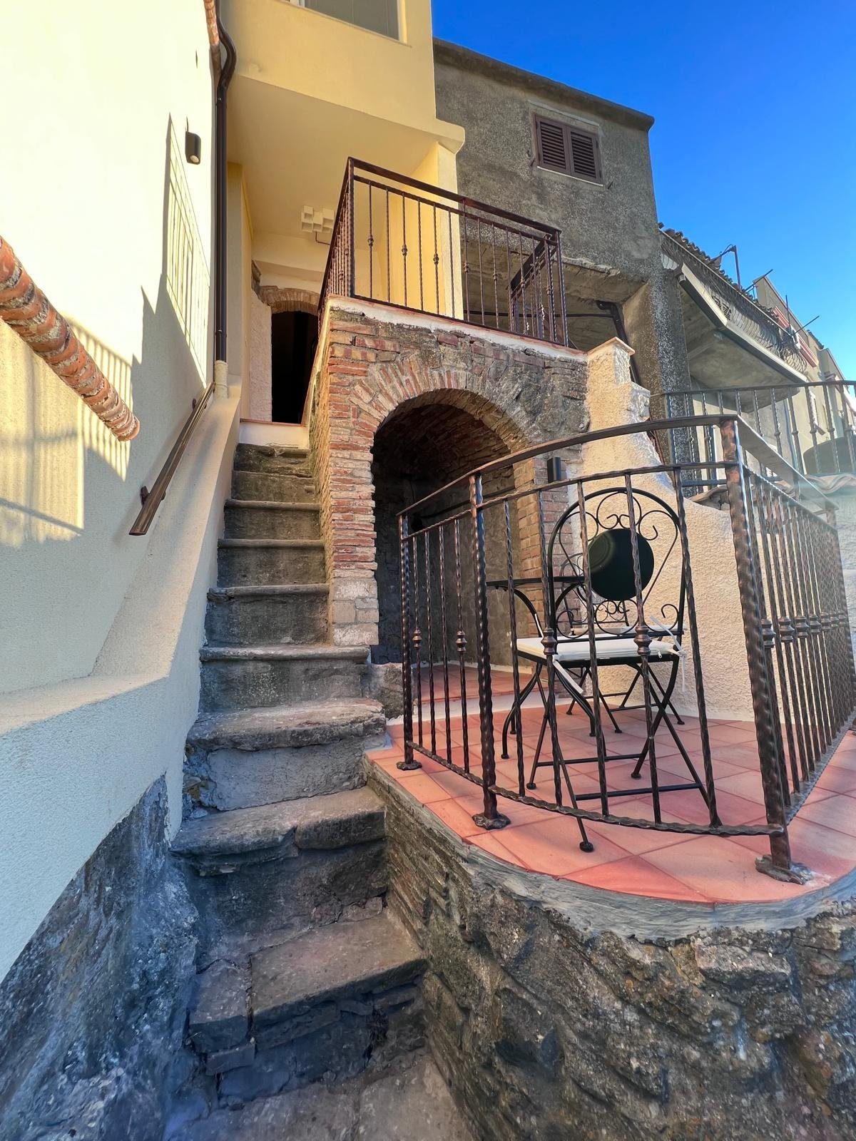 Le scalette di pietra del borgo e un tavolino in ferro battuto
