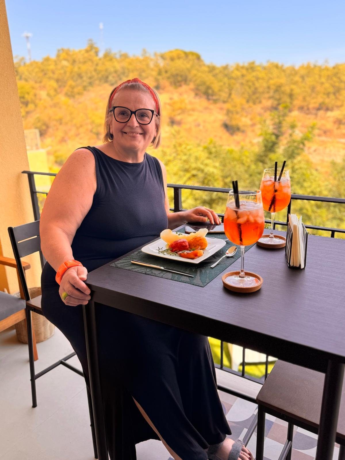 Aperitivo in terrazza con lo spritz e vista sulle colline