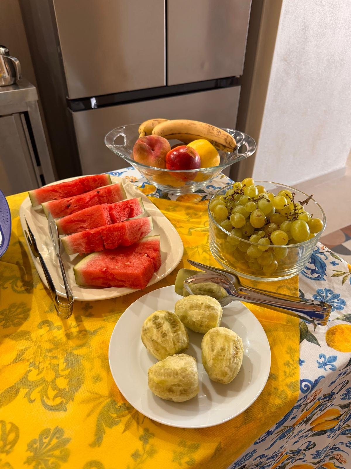 Frutta della colazione: anguria, uva bianca e fichi