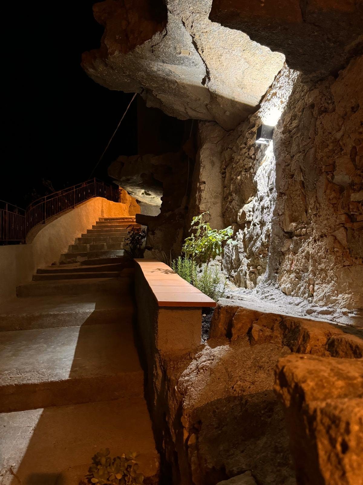 Scalinata di pietra illuminata nel borgo di Cirò, di sera